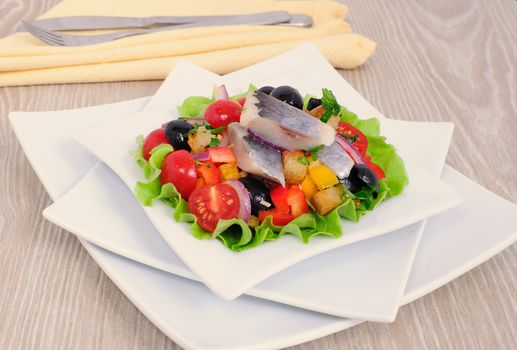 Appetizer of fresh vegetables with crackers and herring