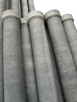 Stack of many asbestos pipes on white background