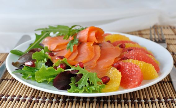 Appetizer of salmon with orange and grapefruit and a mixture of lettuce