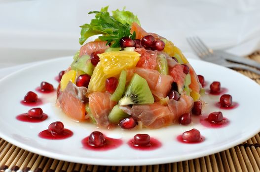 Salad with salmon of different fruits and pomegranate