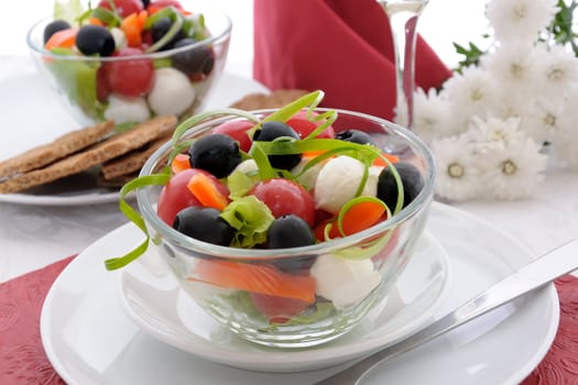 Salad of lettuce, cherry tomatoes, olives and mozzarella with pepper