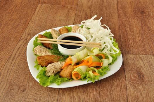 Chicken fillet in breadcrumbs and sesame with fried rice noodles with vegetables