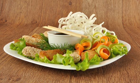 Chicken fillet in breadcrumbs and sesame with fried rice noodles with vegetables