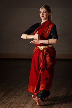 Young woman in sary dancing classical traditional indian dance Bharat Natyam