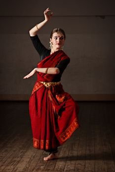 Young woman in sary dancing classical traditional indian dance Bharat Natyam