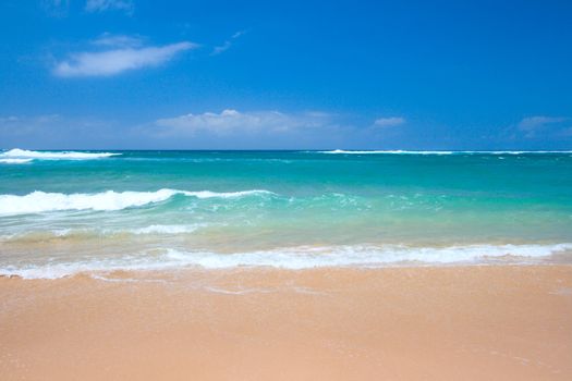 Peaceful beach scene with ocean and blue sky