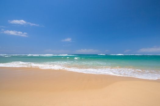 Peaceful beach scene with ocean and blue sky