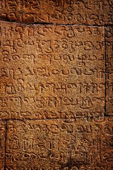 Ancient inscriptions on stone wall in Tamil language. India