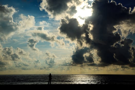 Man silhouette standing on beach on sunrise