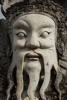 Wat Pho Chinese stone guardian face close up, Bangkok, Thailand