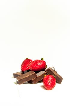 Three fresh strawbwerries on dark chocolate bars