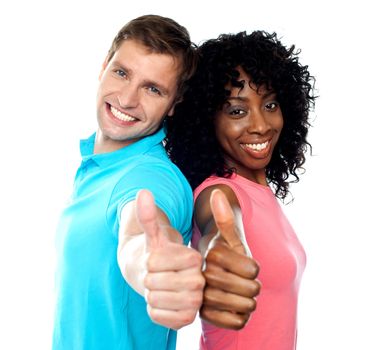 Smiling trendy couple showing thumbs up against white background