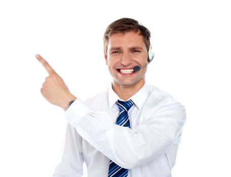 Customer service agent with headsets pointing towards copy space area