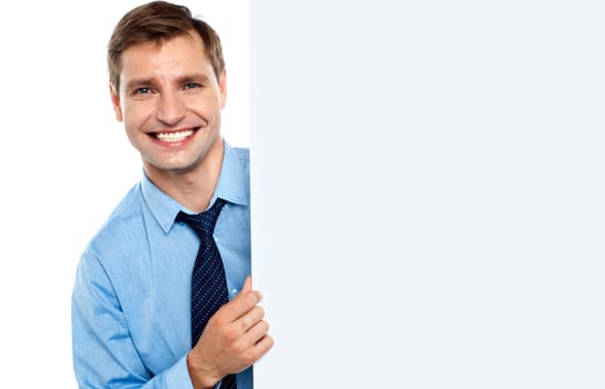 Business man holding a long blank banner ad, smiling at camera