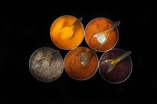 Traditional spices from an East-Indian kitchen, on black studio background.