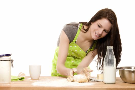 young baking woman forming dough with her hands on white background