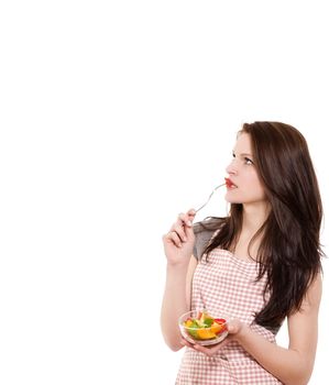 young woman from side eating salad looking up on white background