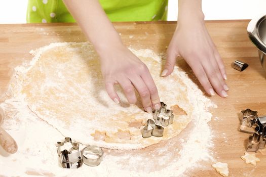 closeup of hands using christmas molds on dough