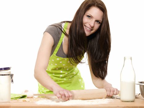 happy woman with rolling pin preparing dough on a table with white background