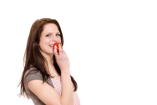 happy young woman about to eat a tomato on white background