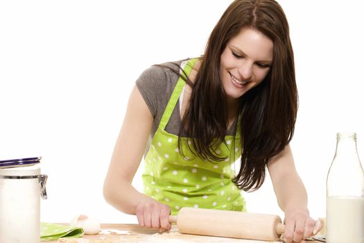 happy young woman using rolling pin on dough with white background