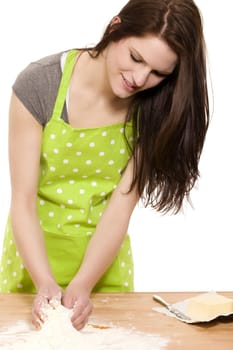 young happy woman mixing dough for baking on a table with white background