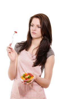 young woman is suspicious about the salad on her fork with white background