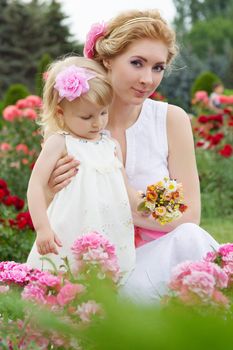 Mother and baby among pink rose garden