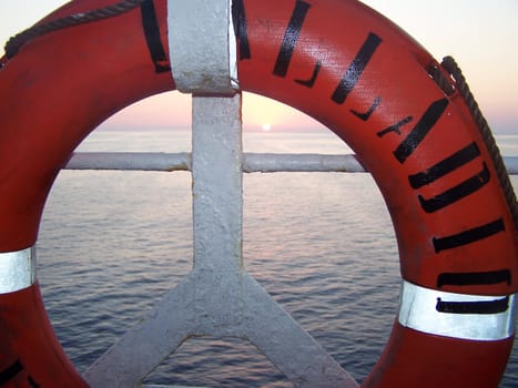 Life buoy in the form of peace and sunset over the sea in the background