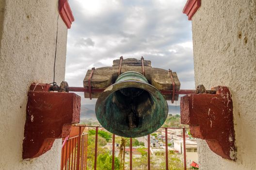 Old bronze bell in bell tower of colonial church