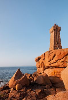 Image of a lighthouse and iconic shaped rocks on the Pink Granite Coast in Brittany in the northwest part of France.