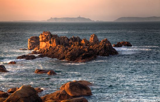 Beautiful sunset over the rocks of Pink Granite Coast in Brittany in the northwest part of France.