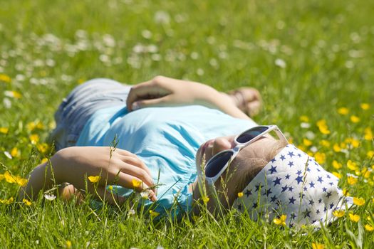 little girl lying on grass 