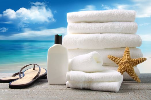 Lotion, towels and sandals with ocean scene