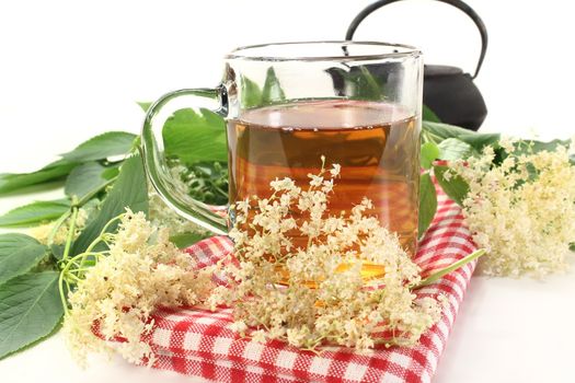 a cup of elderflower tea with fresh flowers