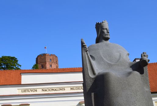 Gediminas castle on high hill, nacional museum of Lithuania and Mindaugas grand duke and first king of Lithuania sculpture on background of blue sky.