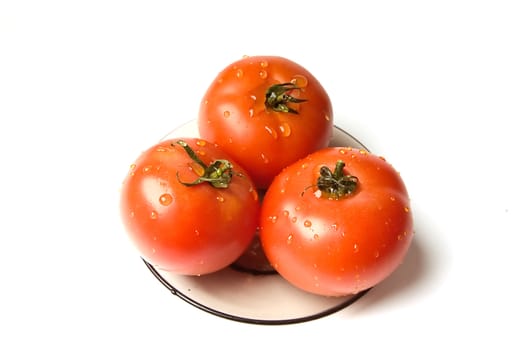 wet tomatoes at the plate on a white background