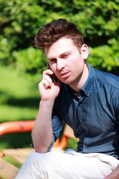 Young handsom man in park calling