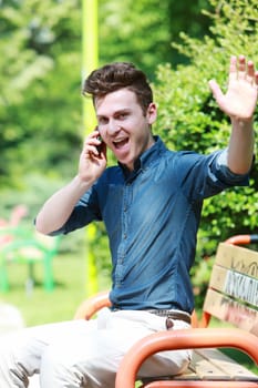 Really happy man in park with telephone
