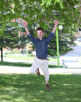 happy and jumping young man in park