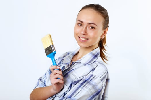 Portrait of young woman with paint brushes