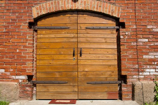 Big wooden doors in red brick wall