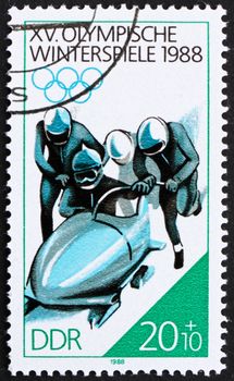 GDR - CIRCA 1988: a stamp printed in GDR shows 4-man Bobsled, 15th Winter Olympics, Calgary, Canada, circa 1988