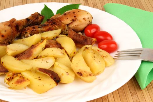 Grilled chicken legs with potatos and tomatos