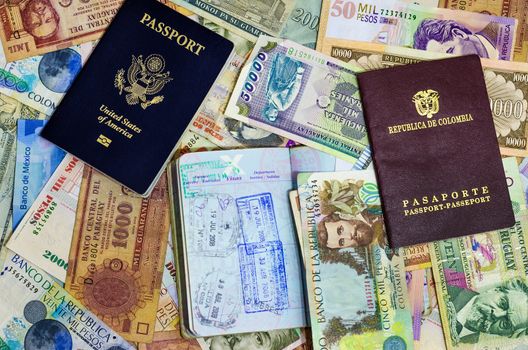 Three passports with various currencies from Latin America