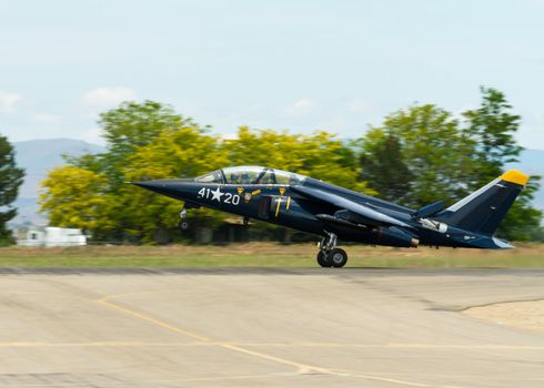 Jet plane on the runway getting ready to take off. shows gear extended and plane still is on the ground by it's rear two wheels