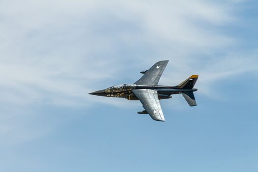 Alpha jet banked in flight against the blue sky