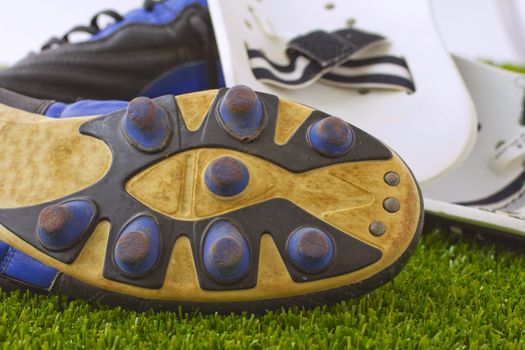 Black, blue and white football shoes over green grass