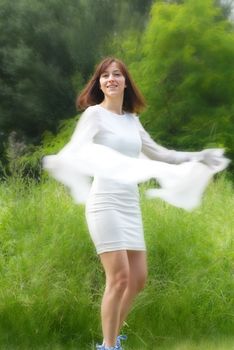 young happy caucasian brunette woman in white dress in green park outdoors