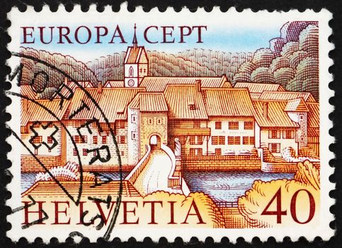 SWITZERLAND - CIRCA 1977: a stamp printed in the Switzerland shows St. Ursanne on Doubs River, Jura, Switzerland, circa 1977